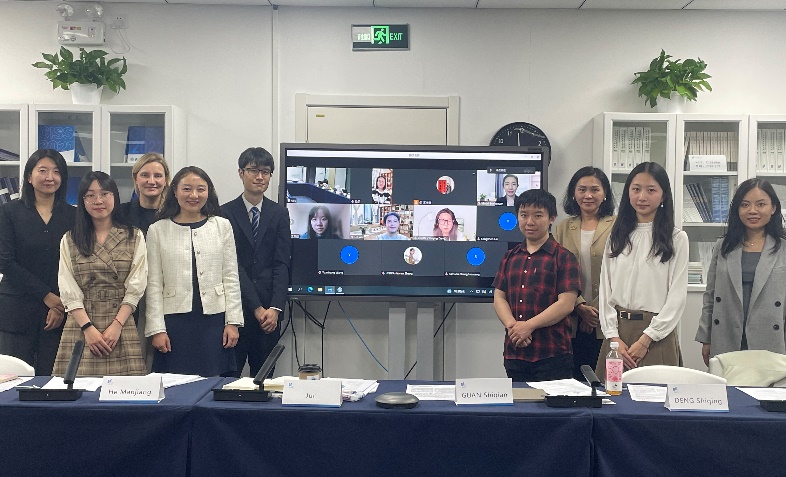 A group of people standing in front of a screenDescription automatically generated